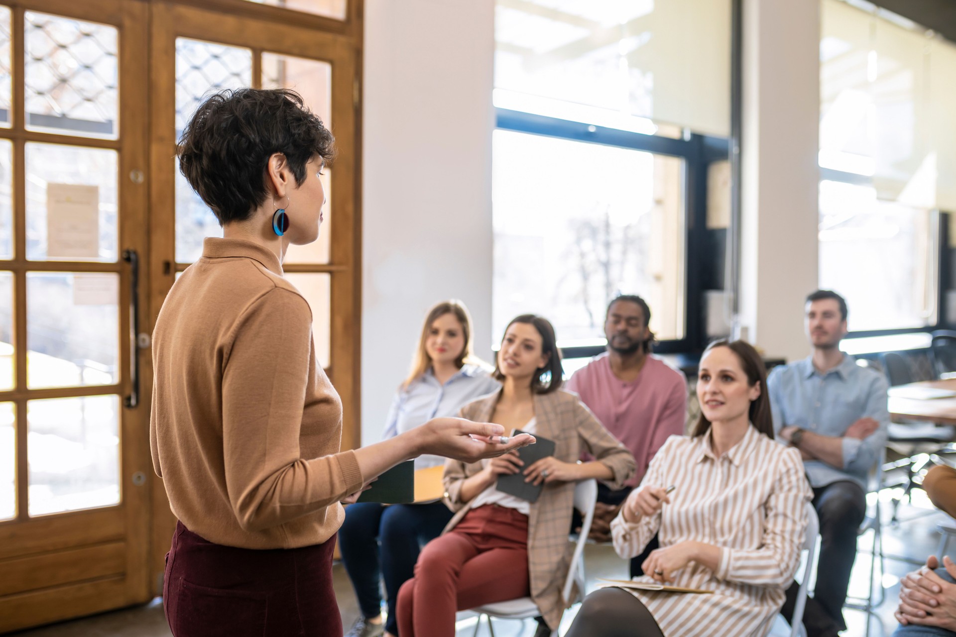 Woman Lecturer Giving Presentation to Businesspeople